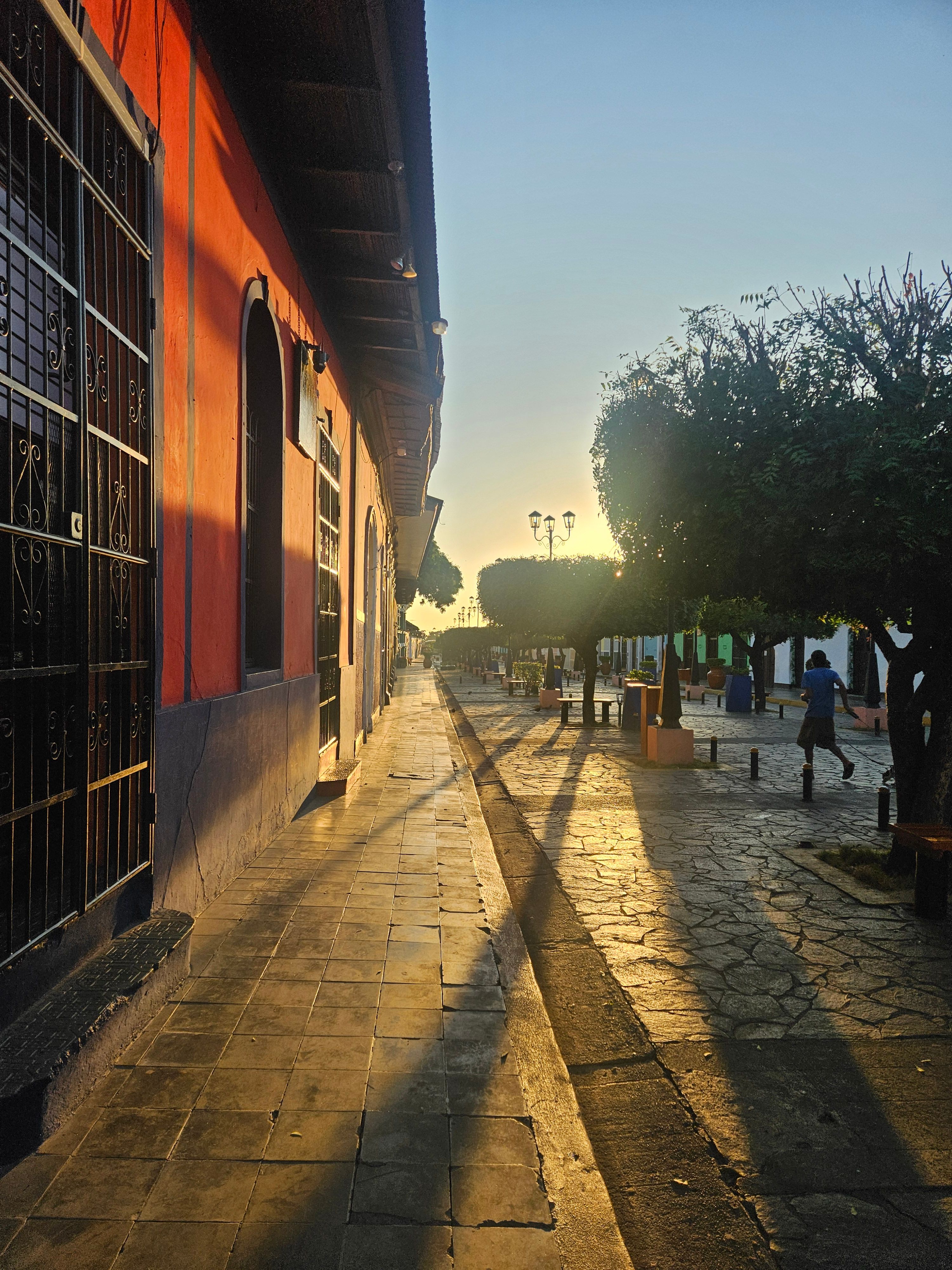 A street in Honduras at sunrise, long shadows across the stones